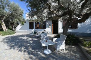 a patio with chairs and a table in front of a house at Bilocale Il Nido in Massa Lubrense