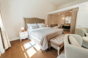 a bedroom with a large bed and a couch at Hotel Château Gbeľany in Žilina