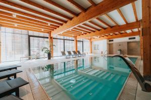 an indoor pool in a house with wooden ceilings at Hotel Château Gbeľany in Žilina