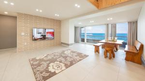 ein Wohnzimmer mit Tisch und Blick auf das Meer in der Unterkunft Gangneung Haerang Pension in Gangneung