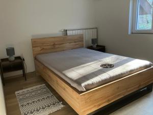 a bed in a room with a wooden bed frame at Borostyán Vendégház - Zalaegerszeg in Zalaegerszeg