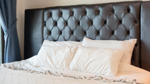 a bed with a black headboard and white pillows at Namhae Ryu&Lee Pet Pension in Namhae