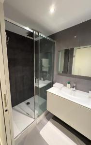 a bathroom with two sinks and a shower at Appartement design au cœur du Marais in Paris +9 photos