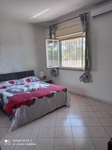 een slaapkamer met een bed en een raam bij Villa Mirko in Vaccarizzo - Delfino