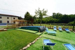 a yard with blue chairs and a pool at Villa Adelaide 22 Pax by VILLASRETREATS in Rometta
