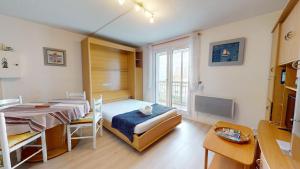 una habitación con dos camas y una mesa y un escritorio en Cap a L Ouest, en Les Bussolleries