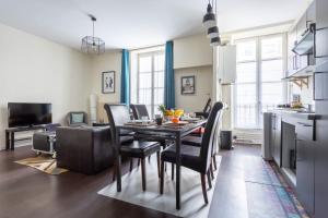 a kitchen and dining room with a table and chairs at Remy - Appt 68 m2 cosy - Place de Jaude & tramway in Clermont-Ferrand +6 photos