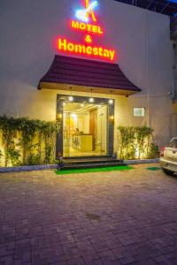 a store with a neon sign on the side of a building at KANHA HOMESTAY & Motel in Phagwāra