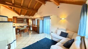 a living room with a white couch and a kitchen at Appartamento Villa Nicole in Transacqua
