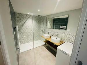 une salle de bain avec deux lavabos et une douche dans l'établissement Agréable maison en centre ville de St Mère Église, à Sainte-Mère-Église 4 autres photos