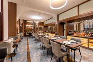 ein Restaurant mit Holztischen und Stühlen und einer Theke in der Unterkunft Riverside Hotel in Vientiane