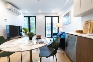 een keuken en woonkamer met een tafel en stoelen bij 149BK-302 New Construction 1BR WD in unit Balcony in Brooklyn