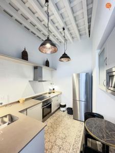 a kitchen with white cabinets and a stainless steel refrigerator at Casa Trajano Grupo AC Gestion in Cádiz