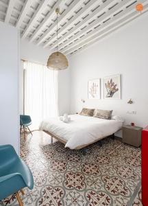 a bedroom with a large bed and a blue chair at Casa Trajano Grupo AC Gestion in Cádiz