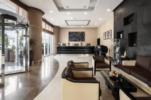 a lobby with couches and chairs and a piano at Cristal Hotel Abu Dhabi in Abu Dhabi
