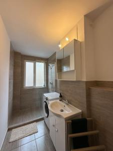 a bathroom with a sink and a washing machine at City Comfort Apartment in Bacău