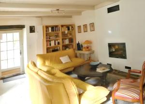 ein Wohnzimmer mit einem gelben Sofa und einem Tisch in der Unterkunft Maison spacieuse à Saint-André-de-Valborgne avec jardin 120 m² in Saint-André-de-Valborgne