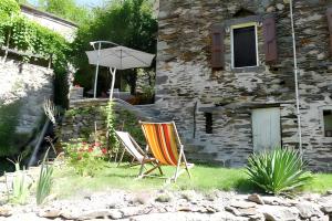ein paar Stühle und ein Regenschirm in einem Hof in der Unterkunft Maison spacieuse à Saint-André-de-Valborgne avec jardin 120 m² in Saint-André-de-Valborgne