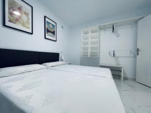 a bedroom with a large white bed in a room at Palmera Beach by Renthas in Pilar de la Horadada +6 photos