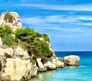 a group of rocks in the water next to the ocean at Bellavista in Torre dell'Orso +15 photos