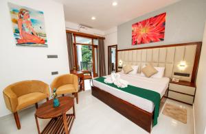 a bedroom with a bed and a table and chairs at Vishwa Retreat Hotel in Kandy