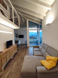 ラヴィースにあるAttico vicino Trento vista montagne mozzafiatoのソファとテレビのあるリビングルーム