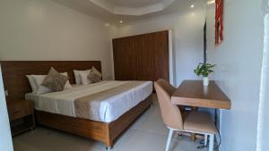 a bedroom with a bed and a table and a desk at K Hotel Kigali in Kigali