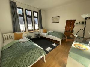 a bedroom with two beds and a couch and windows at Gartenlaube Marburg in Marburg an der Lahn