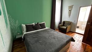 a bedroom with a large bed and a chair at Green bunny ArtHouse in Martvili +35 photos