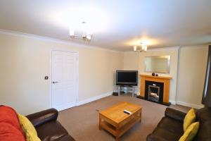 a living room with a couch and a fireplace at Spacious Bracknell Four Bedroom House in Bracknell