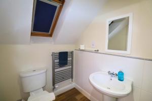 a bathroom with a white toilet and a sink at Spacious Bracknell Four Bedroom House in Bracknell +8 photos