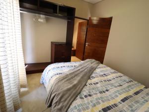 a bedroom with a bed and a dresser at Modern 1 Bedroom Apartment in Bloemfontein