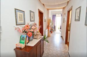 um corredor com uma mesa com flores em B&B Casa Rosino em Dolianova