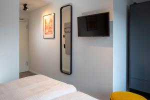 a bedroom with a mirror and a tv on a wall at Wertschätzer Hotel - Krumme Str in Detmold