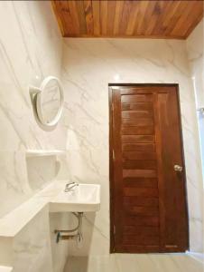 a bathroom with a sink and a wooden door at Rimlay apartment Near Fisherman Bophut in Bophut  +4 photos