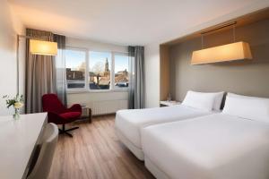 Postel nebo postele na pokoji v ubytování NH Groningen Hotel