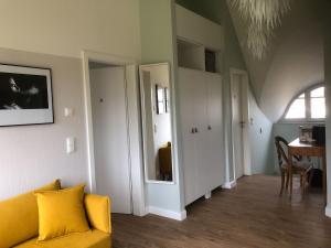 a living room with a yellow couch and a table at Ferienhaus Emma in Kramerhof +20 photos