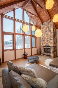 a living room with a couch and a stone fireplace at Sora chalet - Modern house near Rusutsu Resort in Rusutsu