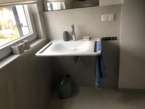a white sink in a bathroom with a window at Ferienhaus Emma in Kramerhof