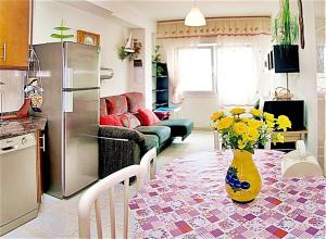 a kitchen with a table with a vase of flowers on it at Apartamento Paseo del Puerto in Finisterre