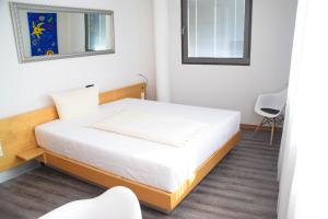 a bedroom with a bed and a mirror and a chair at Cristall Hotel in Waghäusel