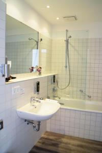 uma casa de banho com um lavatório, um chuveiro e uma banheira em Cristall Hotel em Waghäusel