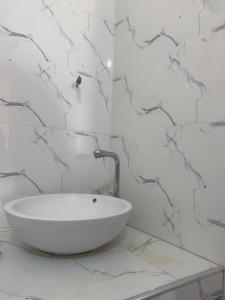 a white bathroom with a sink on a counter at Le Refuge de Touba - Mbacké in Touba
