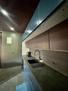 a kitchen with a sink and a counter top at De Monarch, penthouse in Bolinao +10 photos