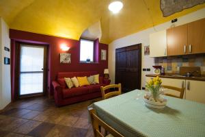 アローナにあるCasa Corte Alla Roccaのリビングルーム(テーブル、赤いソファ付)