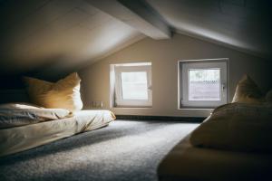 an attic room with two windows and a bed at Ferienhaus Oberspreewald in Schwielochsee