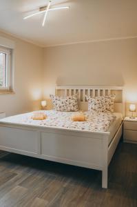 a bedroom with a large white bed with pillows at Ferienhaus Oberspreewald in Schwielochsee