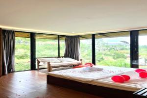 a bedroom with a large bed and a large window at BonBon Villa & Coffee in Bảo Lâm
