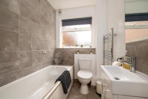 a bathroom with a toilet and a tub and a sink at Ideal 2 Bedroom Ground floor Apartment By Jesswood Properties for Contractors & Business, Free Parking and Wifi in Hinckley +14 photos