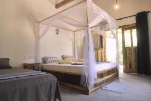 a bedroom with a canopy bed in a room at Kadjan villa in Arugam Bay